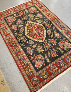 Area Rug from Iran with a Black field and Red border and floral and birds Geometric pattern