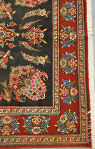 closer look of the Qom Handknotted rug's  bottom left corner border showing carpet's  floral pattern